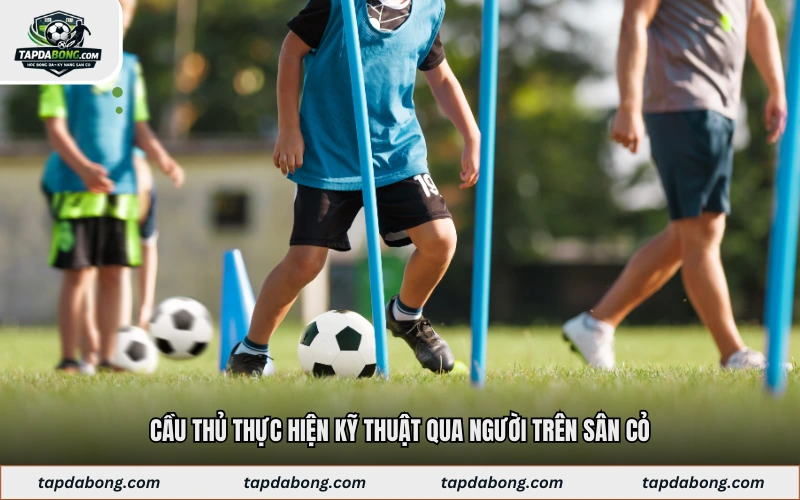 Cầu thủ thực hiện kỹ thuật qua người trên sân cỏ